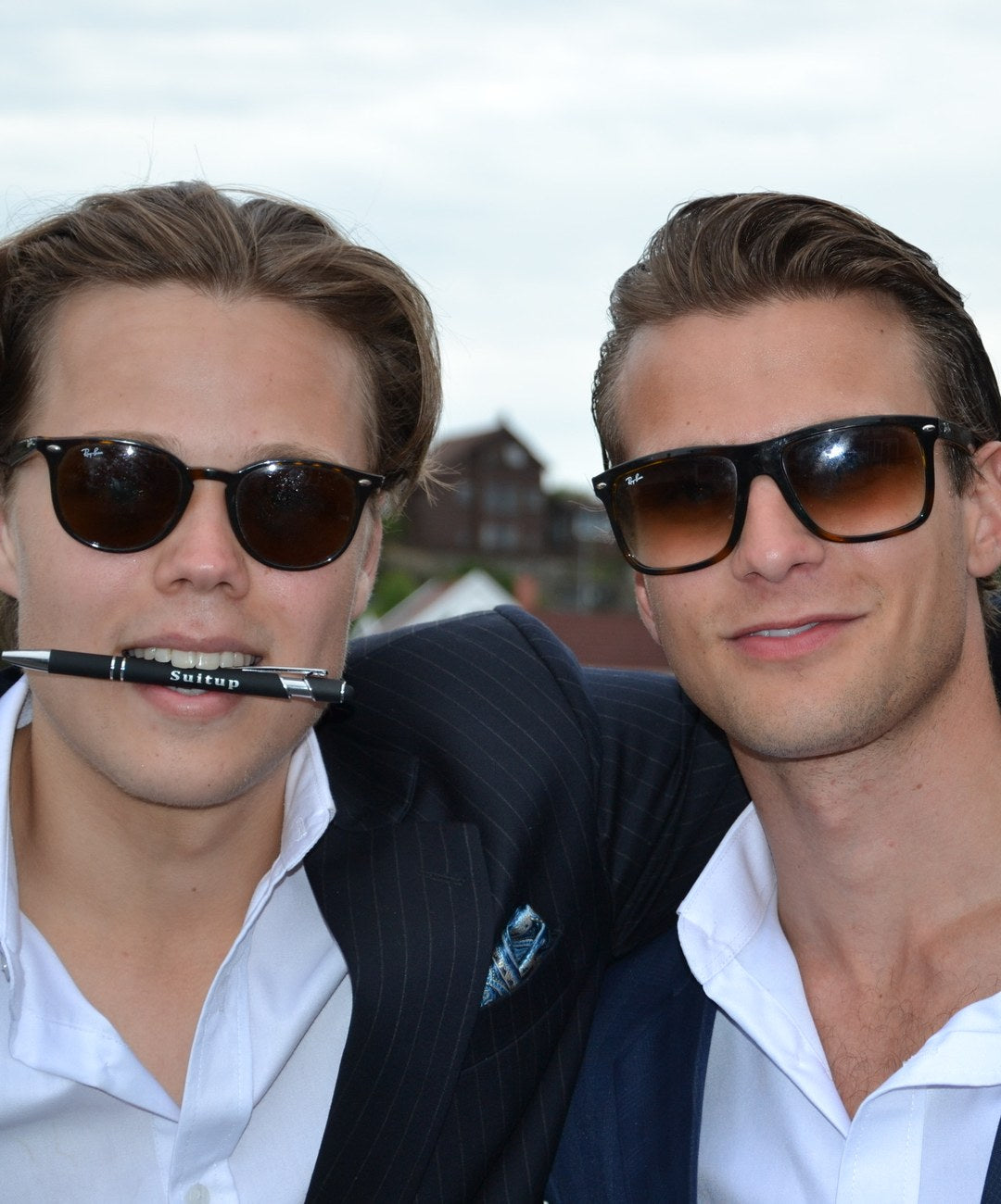 To gutter i SuitUp-dress på SuitUp-festen, den ene med en SuitUp-penn i munnen